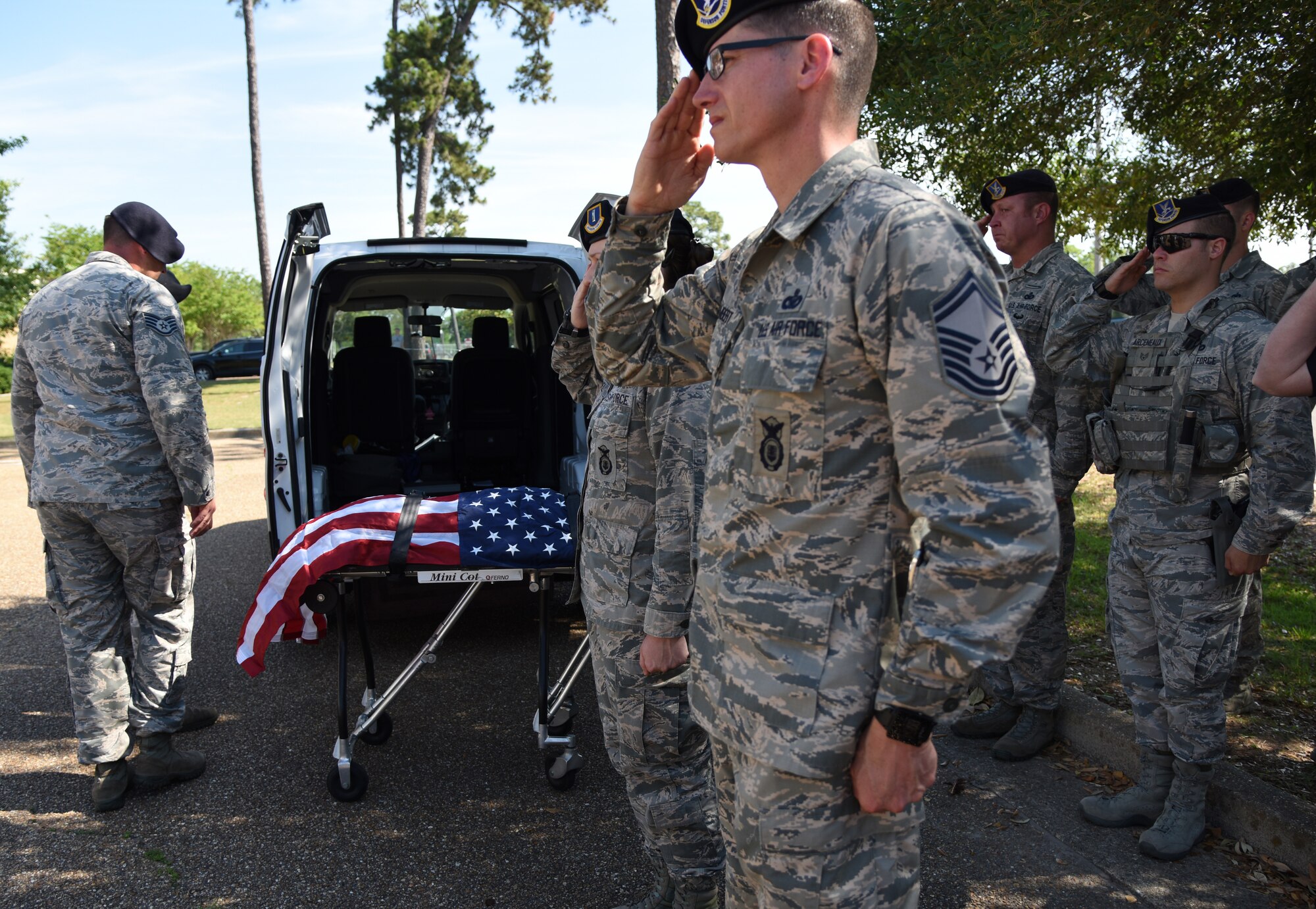 Members of the 81st Security Forces Squadron pay tribute to Ares, 81st SFS retired MWD, during a final salute memorial service outside the vet clinic at Keesler Air Force Base, Mississippi, May 9, 2018. Defenders attended the memorial to pay their respects for Ares, 81st SFS MWD retired, as he was laid to rest. (U.S. Air Force photo by Kemberly Groue)