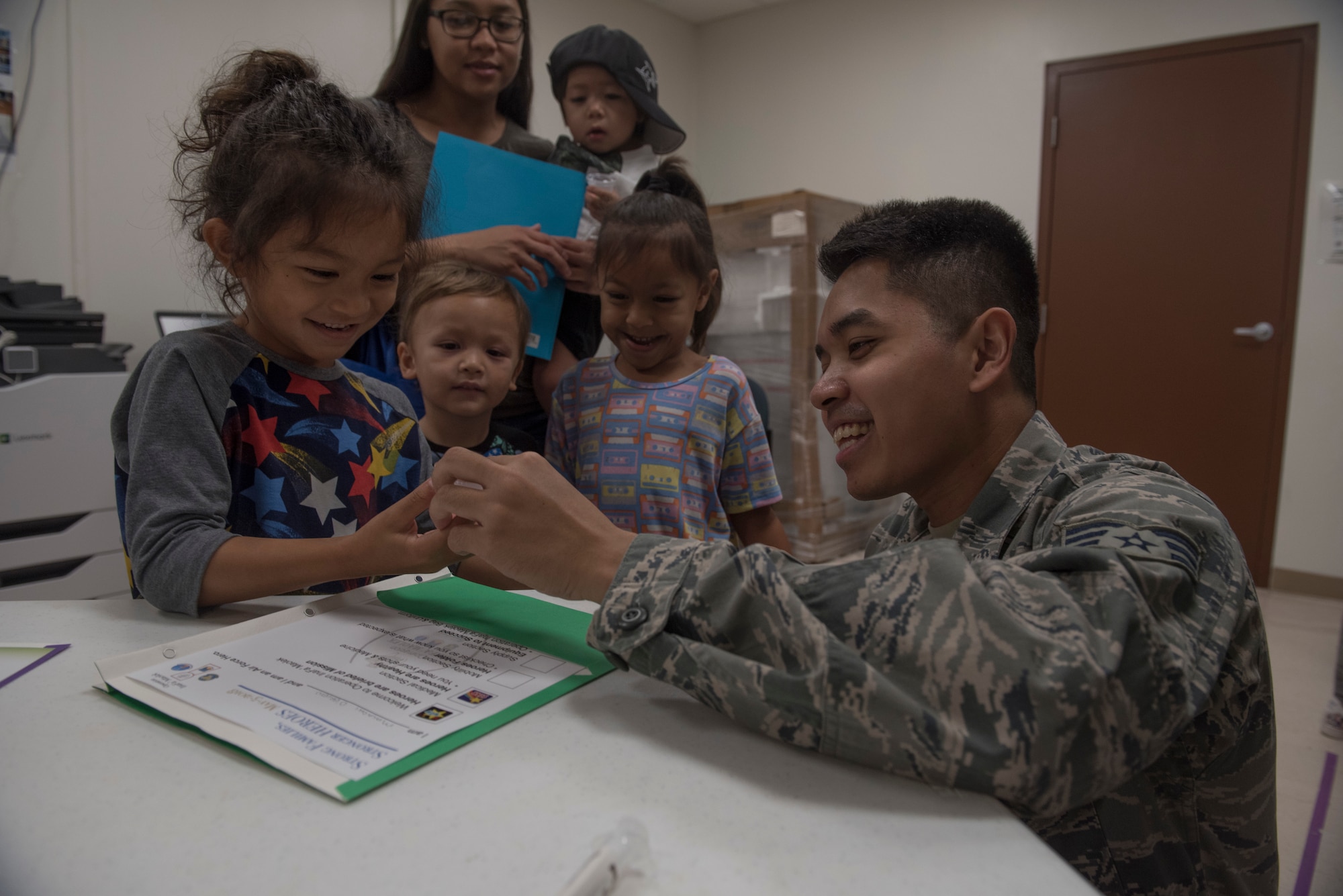 A U.S. Air Force Senior Airman assigned to the U.S. Air Force Reserve’s 44th Aerial Port Squadron, interacts with military children during Operation Inafa’ Maolek at Andersen Air Force Base, May 5, 2018.