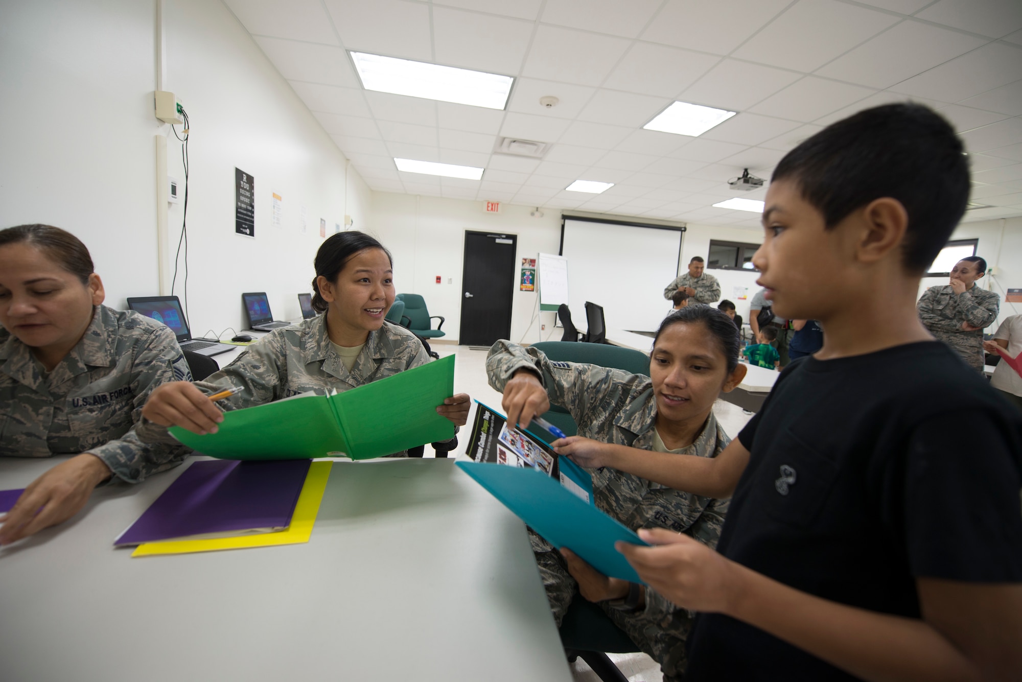U.S. Air Force Staff Sgts. Kaolanie Claros, center, and Sofia Oropesa, right, both assigned to the U.S. Air Force Reserve’s 44th Aerial Port Squadron, introduce military children to readiness activities during Operation Inafa’ Maolek at Andersen Air Force Base, May 5, 2018.
