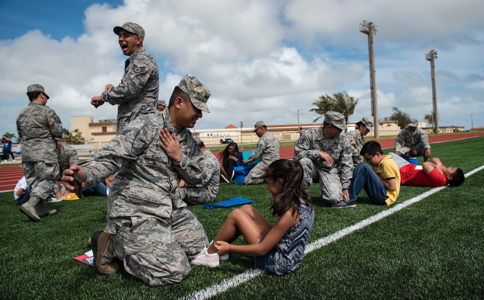 U.S. Air Force Reservists assigned to the 44th Aerial Port Squadron perform physical training games with military children during Operation Inafa’ Maolek at Andersen Air Force Base, May 5, 2018.