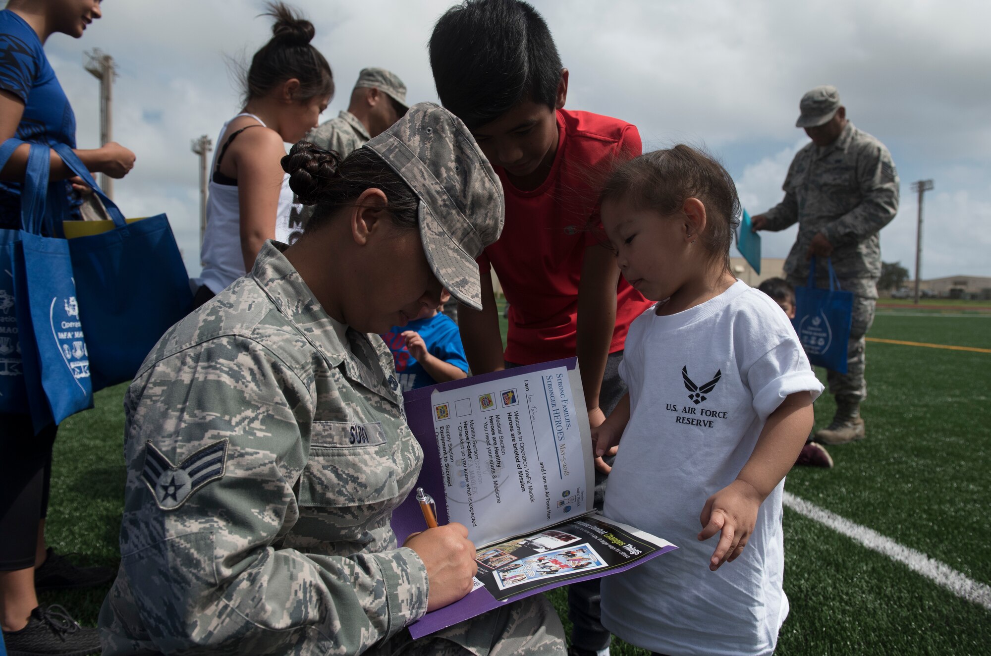 U.S. Air Force Senior Airman Lourkrina M. Sudo, assigned to the U.S. Air Force Reserve’s 44th Aerial Port Squadron, signs off military children for their physical fitness portion of Operation Inafa’ Maolek at Andersen Air Force Base, May 5, 2018.