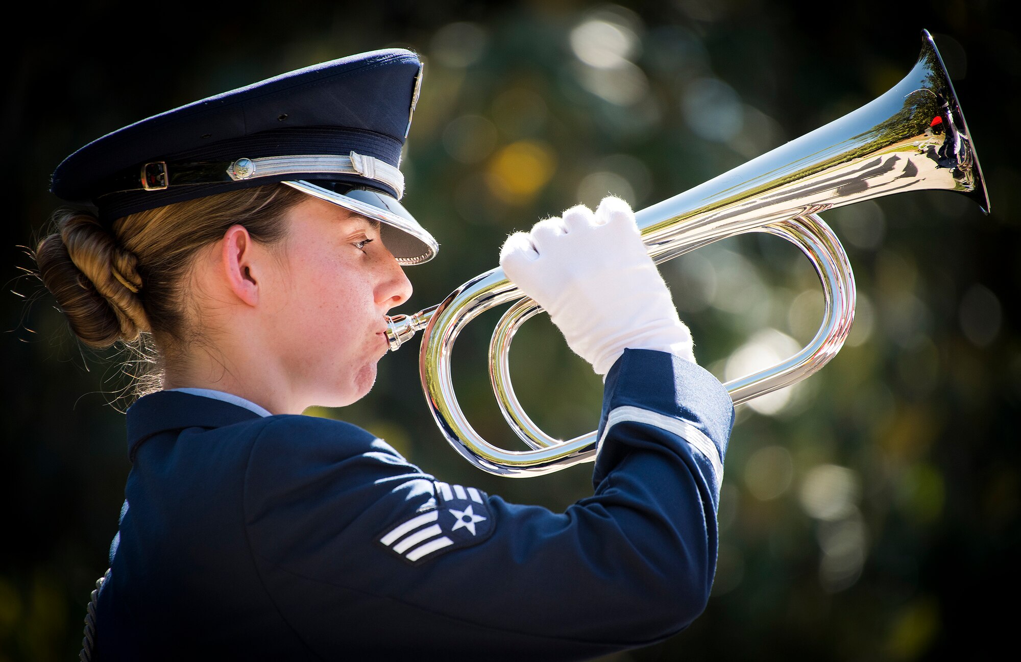 Senior Airman Makayla Scanlan, 96th Surgical Operations Squadron, holds the bugle in place as it plays taps at the 49th Annual Explosive Ordnance Disposal Memorial ceremony May 5, 2018. Names of recent fallen and past EOD technicians are added to the memorial wall and flags presented to their families during a ceremony each year at the Kauffman EOD Training Complex at Eglin Air Force Base, Fla. The Army and Navy added 12 new names this year. The all-service total now stands at 338. (U.S. Air Force photo by Samuel King Jr.)