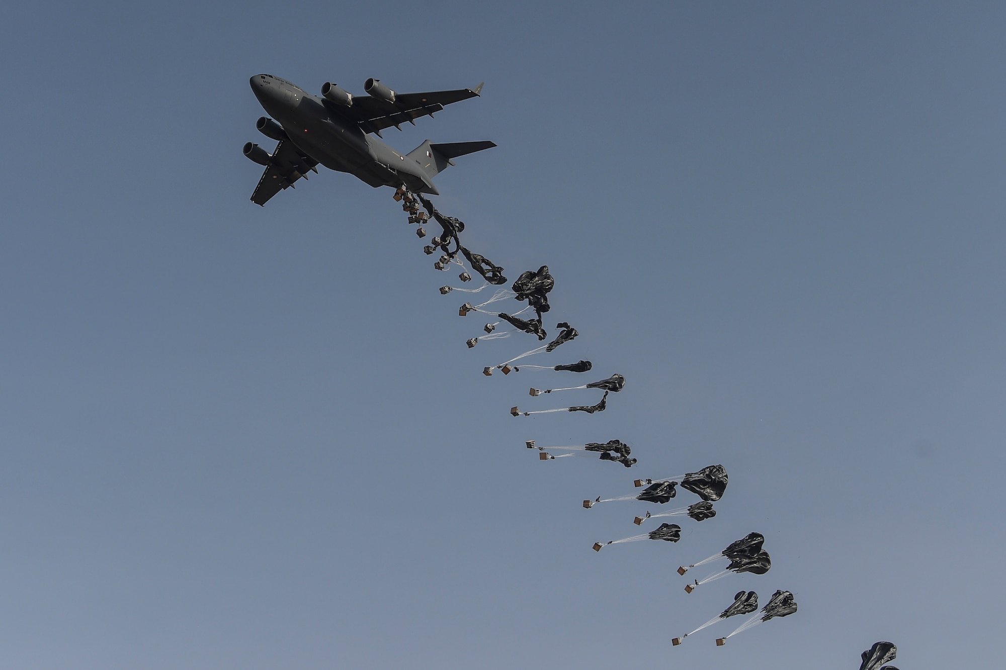 A Qatar Emiri Air Force C-17 Globemaster performs an airdrop during the (QEAF) Lahoub exercise at Al-Qalael dropzone, Qatar, May 9, 2018. The QEAF recently sent one of their C-17 aircrews back to the U.S. to receive airdrop training. This is a new capability for the QEAF and the first C-17 airdrop capability in the Gulf Corporation Council. (U.S. Air Force photo by Staff Sgt. Corey Hook)