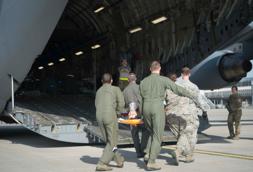 86th Critical Care Air Transport Team Airman transport a simulated burn victim on a C-5 Galaxy during a burn victim evacuation exercise on Ramstein Air Base, Germany, May 9, 2018. The exercise gave CCAT Airmen a chance to work together with the 86th Aeromedical Evacuation Squadron and En-Route Patient Staging Flight, just as they would in a real-world scenario. (U.S. Air Force photo by Senior Airman Elizabeth Baker)