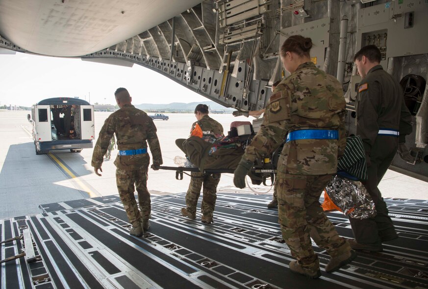 86th Aeromedical Evacuation Squadron and Critical Care Air Transport Team Airmen transport a simulated burn victim from a C-5 to an ambulance bus during a burn victim evacuation exercise on Ramstein Air Base, Germany, May 9, 2018. The 86th Medical Squadron brought together the Aeromedical Evacuation Squadron, CCAT, and En-Route Patient Staging Flight to play their parts in a burn victim evacuation exercise. (U.S. Air Force photo by Senior Airman Elizabeth Baker)