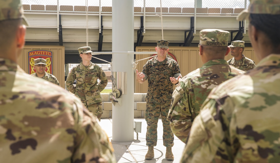 Col. Jay Wiley, assistant chief of staff, Installation Support Directorate, speaks about the soldiers and civilians with the Army's Mojave Branch Veterinary Services, U.S. Army Public Health who received the Army Commedation Medal and the Army's Achievment Medal for Civilian Service at the flag pole aboard the Marine Corps Air Ground Combat Center, Twentynine Palms, Calif., May 2, 2018. The soldiers and civilians received the medals for assisting and stabilizing a motorcyclist involved in a car accident in the local community. (U.S. Marine Corps photo by Lance Cpl. Dave Flores)