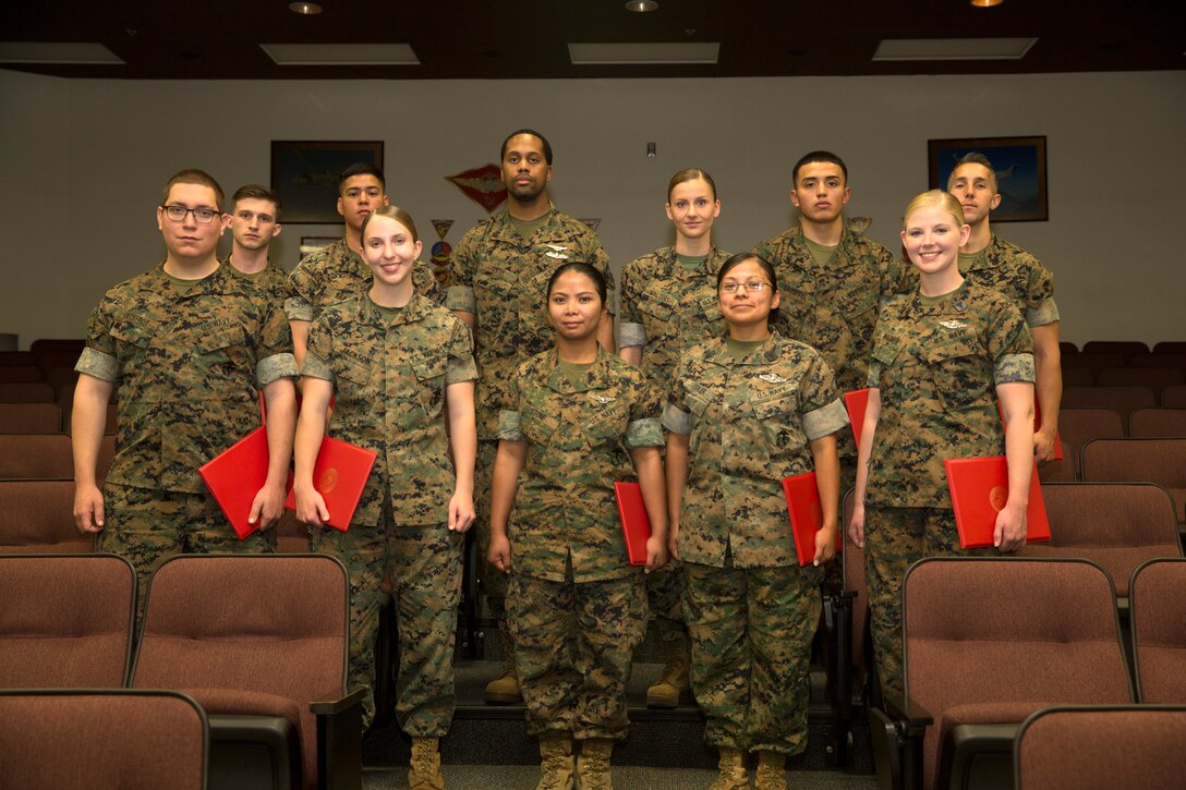 Noncommissioned officers (NCOs), Marines and Sailors of the quarter at Marine Corps Air Station Miramar stand as a group following a ceremony recognizing their accomplishment at MCAS Miramar, Calif., May 9. NCOs, Marines and Sailors of the quarter are chosen because they have demonstrated exceptional performance and exemplified good leadership. From left to right and beginning with the first row, the NCOs, Marines and Sailors of the quarter are as follows: Petty Officer 3rd Class Jacob Geoffroy, Lance Cpl. Elisabeth Jackson, Petty Officer 2nd Class Irish Stone, Petty Officer 1st Class Noemi Coler, Petty Officer 2nd Class Amanda Wagner, Cpl. Robert Schaller, Lance Cpl. Isaac Kear, Petty Officer 1st Class Michael Smith, Sgt. Alina Walters, Cpl. Karlo Esquivel and Sgt. Matthew Leonard. (U.S. Marine Corps photo by Cpl. Jake M.T. McClung/Released)