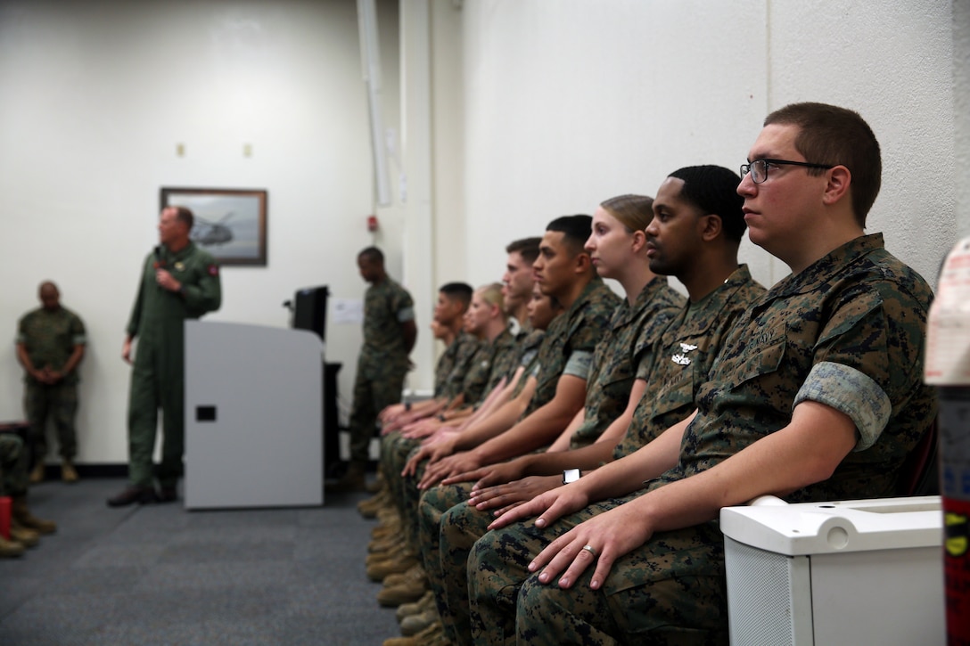 Noncommissioned officers (NCOs), Marines and Sailors listen to Maj. Gen. Mark Wise, commanding general of 3rd Marine Aircraft Wing, as he speaks at the NCO, Marine and Sailor of the quarter ceremony at Marine Corps Air Station Miramar, Calif., May 9. NCOs, Marines and Sailors of the quarter are chosen because they have demonstrated exceptional performance and exemplified good leadership. From left to right and beginning with the first row, the NCOs, Marines and Sailors of the quarter are as follows: Petty Officer 3rd Class Jacob Geoffroy, Lance Cpl. Elisabeth Jackson, Petty Officer 2nd Class Irish Stone, Petty Officer 1st Class Noemi Coler, Petty Officer 2nd Class Amanda Wagner, Cpl. Robert Schaller, Lance Cpl. Isaac Kear, Petty Officer 1st Class Michael Smith, Sgt. Alina Walters, Cpl. Karlo Esquivel and Sgt. Matthew Leonard. (U.S. Marine Corps photo by Cpl. Jake M.T. McClung/Released)