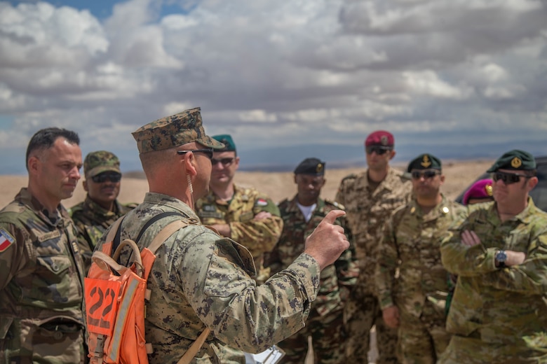 An exercise controller with Tactical Training Exercise Control Group briefs international military officers before a fire support coordination exercise at Observation Post Left aboard the Marine Corps Air Ground Combat Center, Twentynine Palms, Calif., May 2, 2018. The international officers are students at the Command and Staff College, Marine Corps University, Marine Corps Base Quantico, Va., and are set to graduate June 6, 2018. (U.S. Marine Corps photo by Lance Cpl. Preston L. Morris)