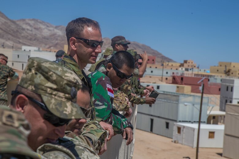 International military officers observe urban lane training at Range 220 aboard the Marine Corps Air Ground Combat Center, Twentynine Palms, Calif., May 2, 2018. The international officers are students at the Command and Staff College, Marine Corps University, Marine Corps Base Quantico, Va., and are set to graduate June 6, 2018. (U.S. Marine Corps photo by Lance Cpl. Preston L. Morris)