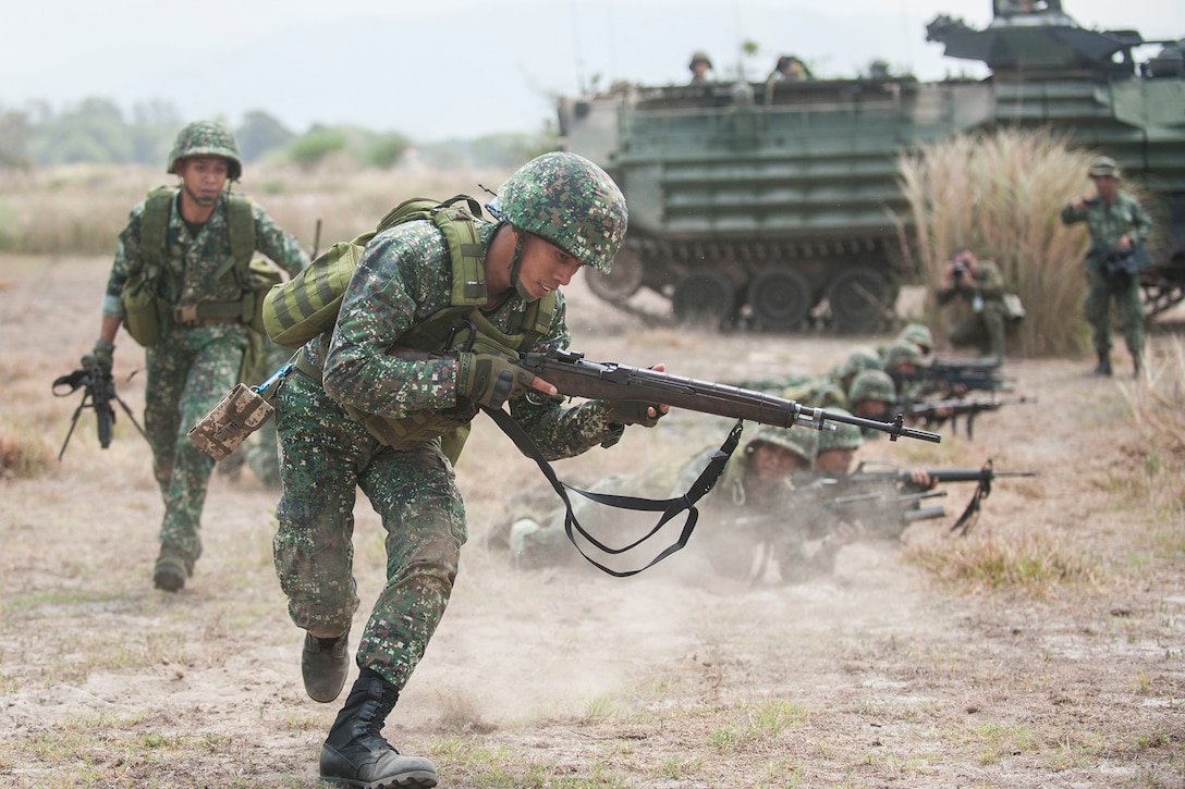 Two Philippine marines run to get into position during an assault exercise.