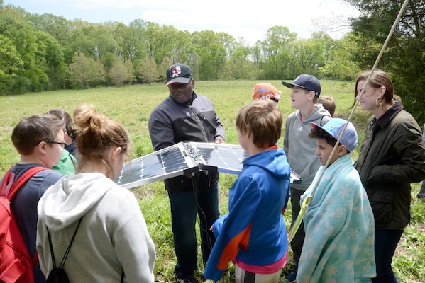 Karl Gullatte, a project manager and community planner with the Center’s Engineering Directorate, center, shows fifth-graders a set of working solar panels during Redstone Arsenal's Earth Day outdoor educational event April 19, 2018.