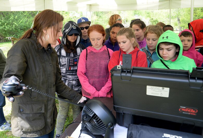 Chandler Word, a Department of the Army intern with the Interior Design Branch, shows fifth-graders how voltage corresponds to light intensity during a solar power demonstration at Redstone Arsenal's Path to Nature Wetland and Indian Education Center as part of Redstone's Earth Day outdoor educational event April 19, 2018.