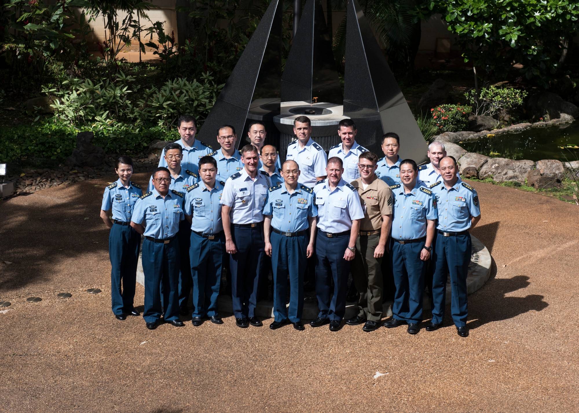 Chinese Maj. Gen. Lan, Deputy Political Commissary/Secretary of Discipline Inspection, People's Liberation Army Air Force (PLAAF) Command College and (Center Right) Brig. Gen. Michael Winkler, Pacific Air Forces (PACAF) Strategy, Plans and Programs director and attendees pose for a photo in the Court Yard of Heroes at Joint Base Pearl Harbor-Hickam, April 26, 2018.