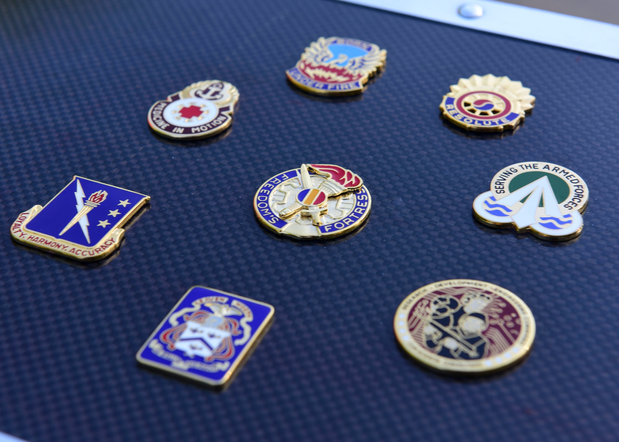 U.S. Army unit challenge coins are placed on Joint Base Langley-Eustis’ time capsule at Fort Eustis, Virginia, May 11, 2018. The time capsule contains memorabilia from across JBLE organizations. (U.S. Air Force photo by Airman 1st Class Monica Roybal)