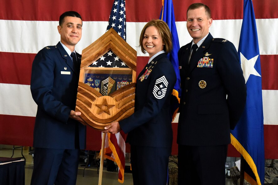 U.S. Air Force Col. Ricky Mills, 17th Training Wing commander, and Col. Jeffrey Sorrell, 17th TRW vice commander, present Chief Master Sgt. Bobbie Fillbrandt with a shadow box from the wing in celebration of her retirement at the Louis F. Garland Department of Defense Fire Academy on Goodfellow Air Force Base, Texas, May 10, 2018. The shadow box, designed in the shape of chief’s stripes, included symbols of all the ranks in the U.S. Air Force, a folded flag and other various memorabilia from Fillbrandt’s career. (U.S. Air Force photo by Airman 1st Class Seraiah Hines/Released)