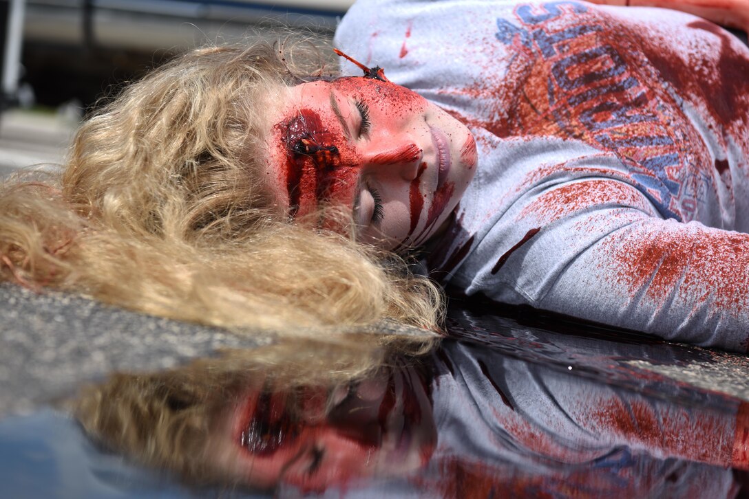 A student performer plays dead as a result of a drunk driving car crash during Freshman Impact at Douglas High School, Box Elder S.D., May 9, 2018. This event teaches young adults the dangers of driving under the influence and distracted driving so they can make better decisions behind the wheel. (U.S.  Air Force photo by Airman 1st Class Thomas Karol)