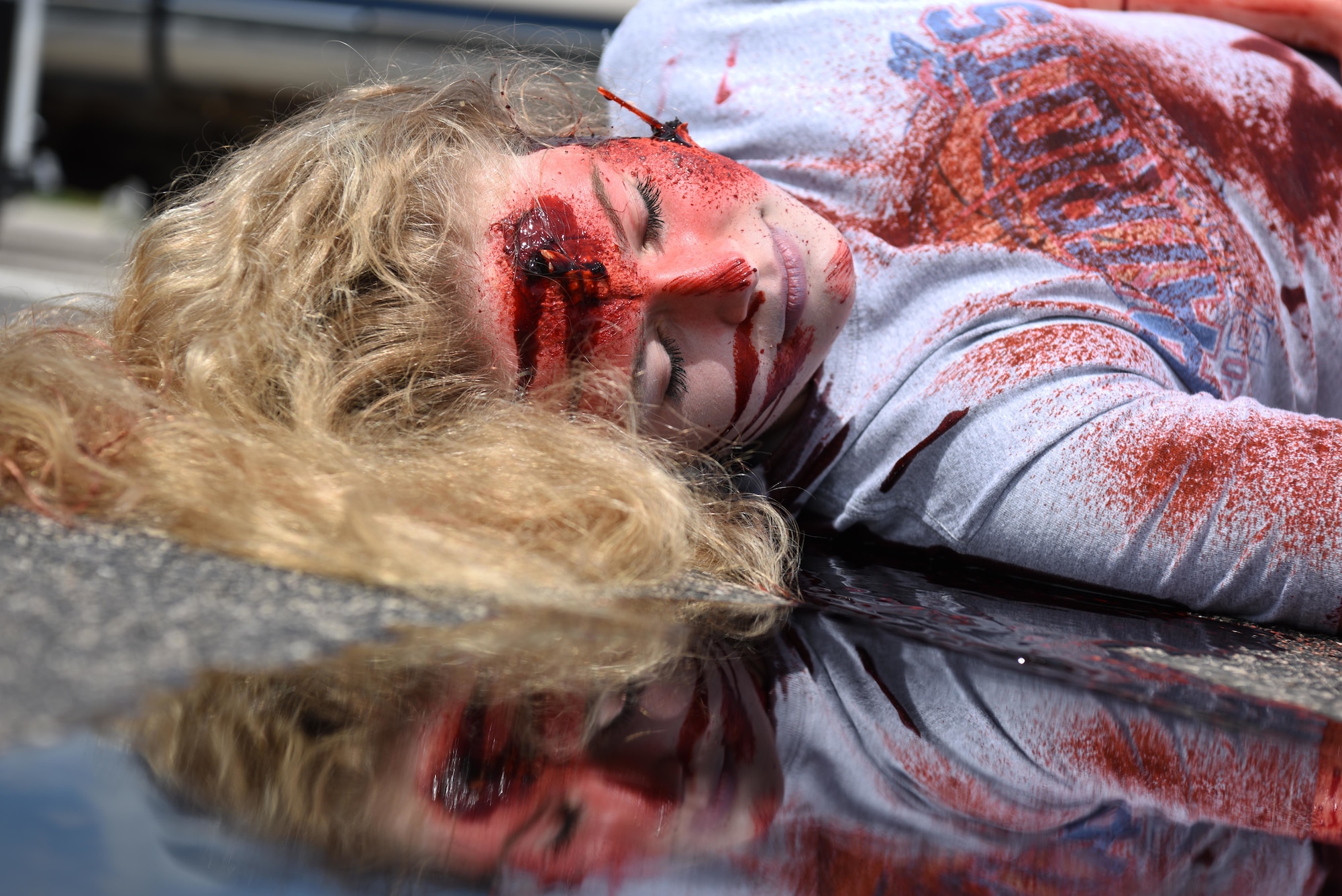 A student performer plays dead as a result of a drunk driving car crash during Freshman Impact at Douglas High School, Box Elder S.D., May 9, 2018. This event teaches young adults the dangers of driving under the influence and distracted driving so they can make better decisions behind the wheel. (U.S.  Air Force photo by Airman 1st Class Thomas Karol)