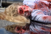A student performer plays dead as a result of a drunk driving car crash during Freshman Impact at Douglas High School, Box Elder S.D., May 9, 2018. This event teaches young adults the dangers of driving under the influence and distracted driving so they can make better decisions behind the wheel. (U.S.  Air Force photo by Airman 1st Class Thomas Karol)