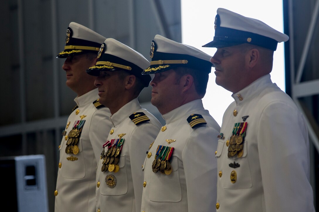 From the left, U.S. Navy Capt. David P. Walt, Commodore, Helicopter Maritime Strike Wing, Pacific, Cmdr. Teague Suarez, off-going commanding officer, Cmdr. Gabriel Kelly, on-coming commanding officer, Master Chief Petty Officer Robert Cuddeback, Command Master Chief, stand at attention during the Helicopter Maritime Strike Squadron 37 change of command, Marine Corps Base Hawaii, May 3, 2018. Cmdr. Teague J. Suarez relinquished command to Cmdr. Gabriel Kelly. (U.S. Marine Corps photo by Sgt. Alex Kouns)