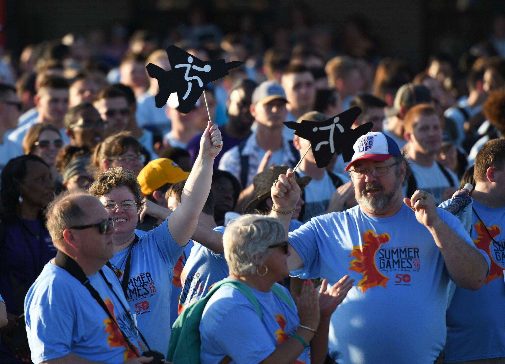 Athletes display cutout aircrafts during the Special Olympics Mississippi 2018 Summer Games opening ceremony at the Training Levitow Training Support Facility drill pad at Keesler Air Force Base, Mississippi, May 11, 2018. Founded in 1968, Special Olympics hosts sporting events around the world for people of all ages with special needs to include more than 700 athletes from Mississippi. This years theme is "Off We Go!" (U.S. Air Force photo by Kemberly Groue)