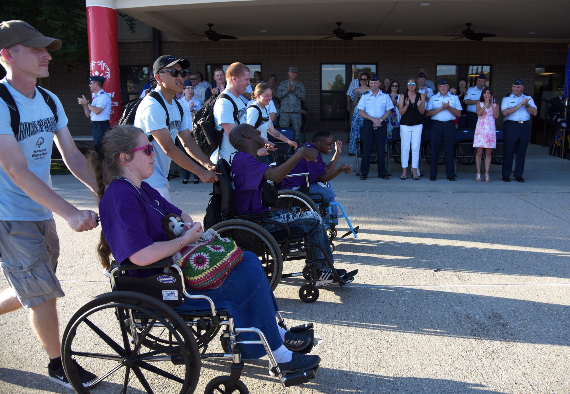 Keesler leadership cheer on athletes and their Airmen sponsors as they make their way down the troop walk during the Special Olympics Mississippi 2018 Summer Games opening ceremony at the Training Levitow Training Support Facility drill pad at Keesler Air Force Base, Mississippi, May 11, 2018. Founded in 1968, Special Olympics hosts sporting events around the world for people of all ages with special needs to include more than 700 athletes from Mississippi. (U.S. Air Force photo by Kemberly Groue)