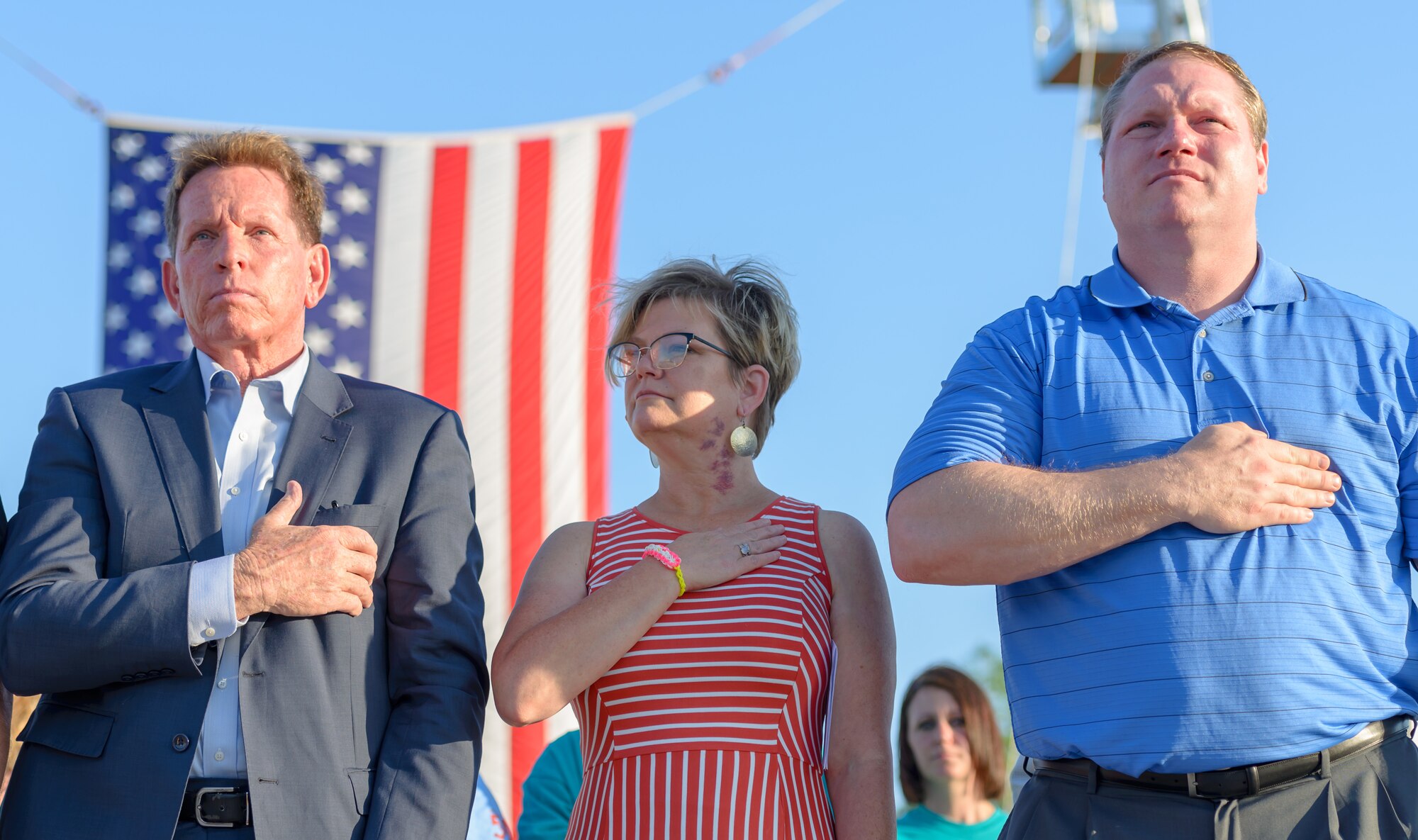 An Honorary commander and Special Olympics Mississippi representatives place their hands over their heart during the National Anthem at the Special Olympics Mississippi 2018 Summer Games opening ceremony at the Levitow Training Support Facility drill pad at Keesler Air Force Base, Mississippi, May 11, 2018. Founded in 1968, Special Olympics hosts sporting events around the world for people of all ages with special needs to include more than 700 athletes from Mississippi. (U.S. Air Force photo by Andre' Askew)