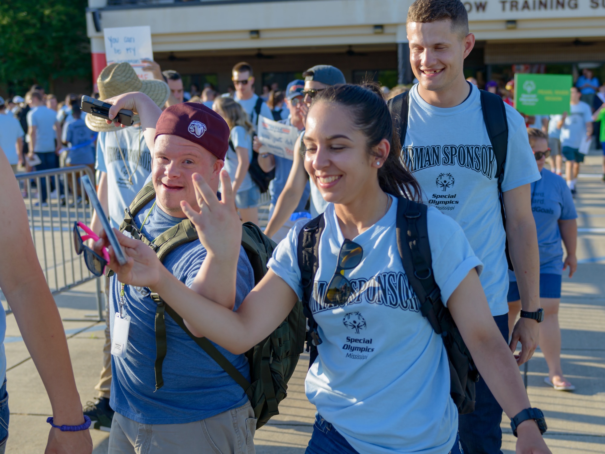 Airmen sponsors and athletes walk onto the Levitow Training Support Facility drill page during the Special Olympics Mississippi 2018 Summer Games opening ceremonies May 11, 2018, on Keesler Air Force Base, Miss. Founded in 1968, Special Olympics hosts sporting events around the world for people of all ages with special needs to include more than 700 athletes from Mississippi. (U.S. Air Force photo by Andre Askew)