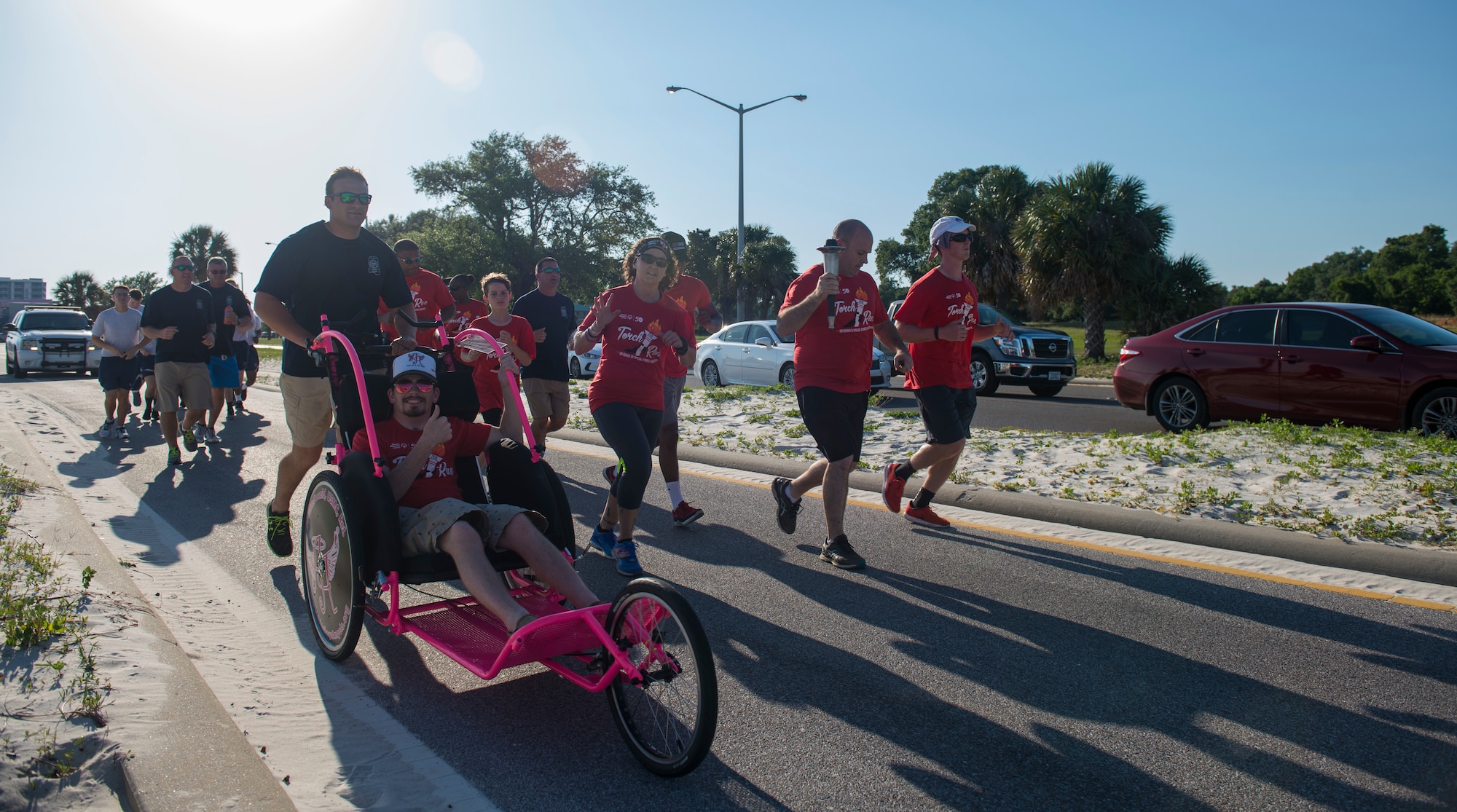 Mississippi police officers and Special Olympics Mississippi athletes run during the SOMS 2018 Summer Games torch run in Biloxi, Mississippi, May 11, 2018. Founded in 1968, Special Olympics hosts sporting events around the world for people of all ages with special needs to include more than 700 athletes from Mississippi. (U.S. Air Force photo by Senior Airman Travis Beihl)