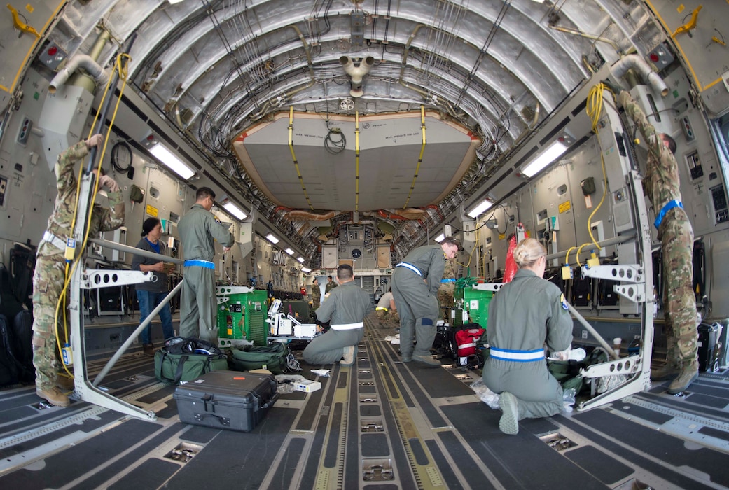 86th Aeromedical Evacuation Squadron and Critical Care Air Transport Team Airmen transform a C-5 Galaxy into a flying hospital during a burn victim evacuation exercise on Ramstein Air Base, Germany, May 9, 2018. The CCATT specializes in caring for critical care patients, while AES handles non-critical patients, and installs and connect equipment to the aircraft. (U.S. Air Force photo by Senior Airman Elizabeth Baker)