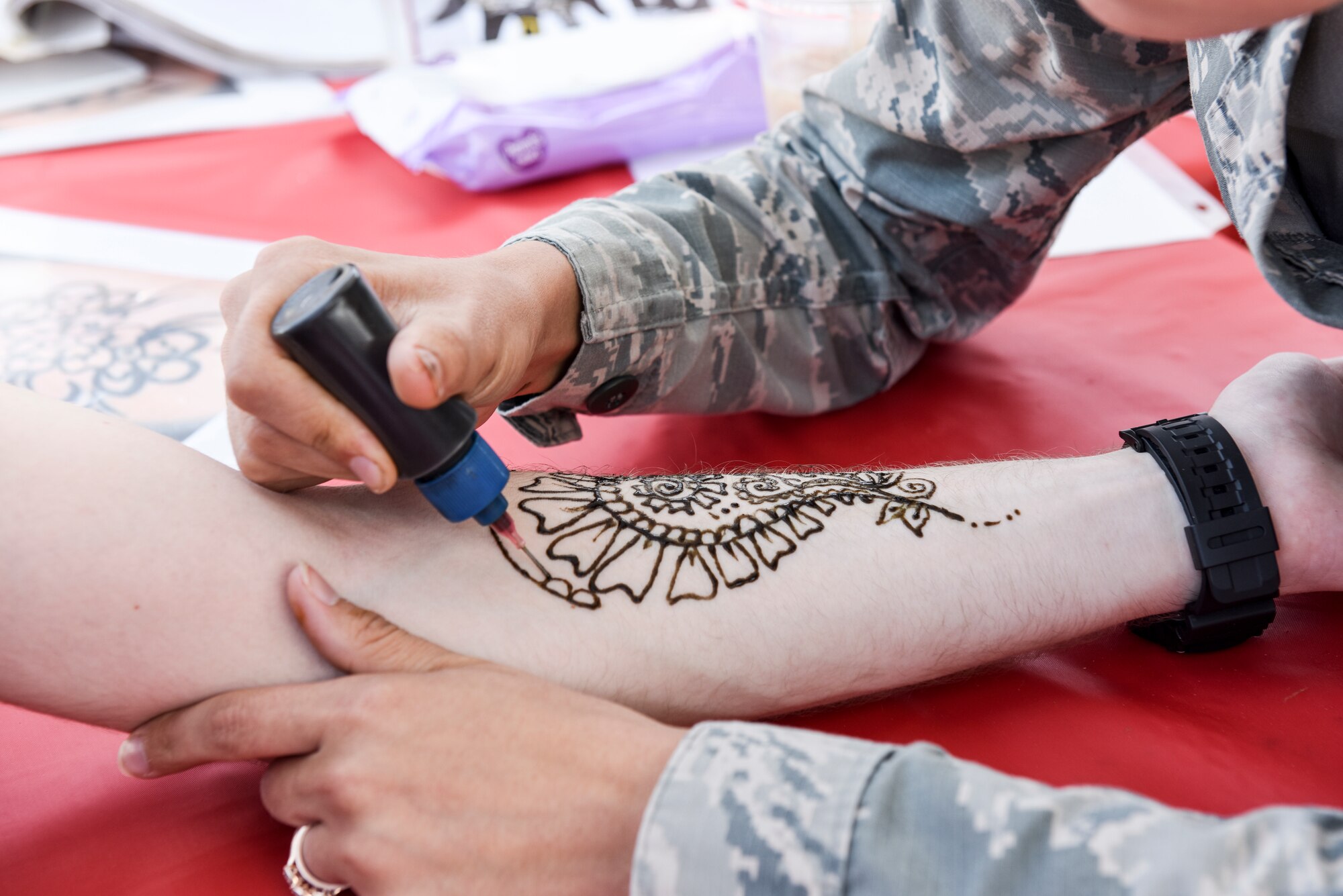 Students draw henna tattoos on visitors during the Defense Language Institute Foreign Language Center's Language Day at the Presideo of Monterey, California, May 11, 2018. In addition to performances on stage, students and faculty set up cultural tents showcasing cultural items, games and activities.