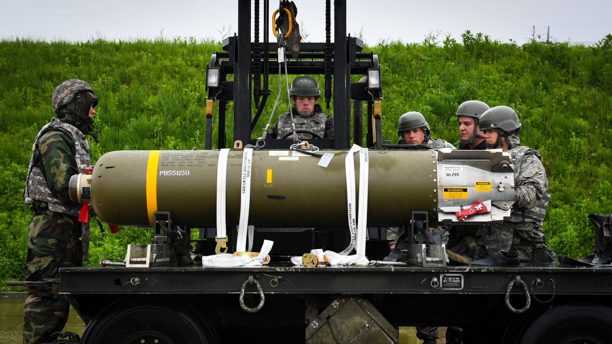 Airmen participating in Combat Ammunition Production Exercise 2018, a combat ammunition production exercise, load a cluster bomb unit on Gwangju Air Force Base, Gwangju, Republic of Korea, May 7, 2018.