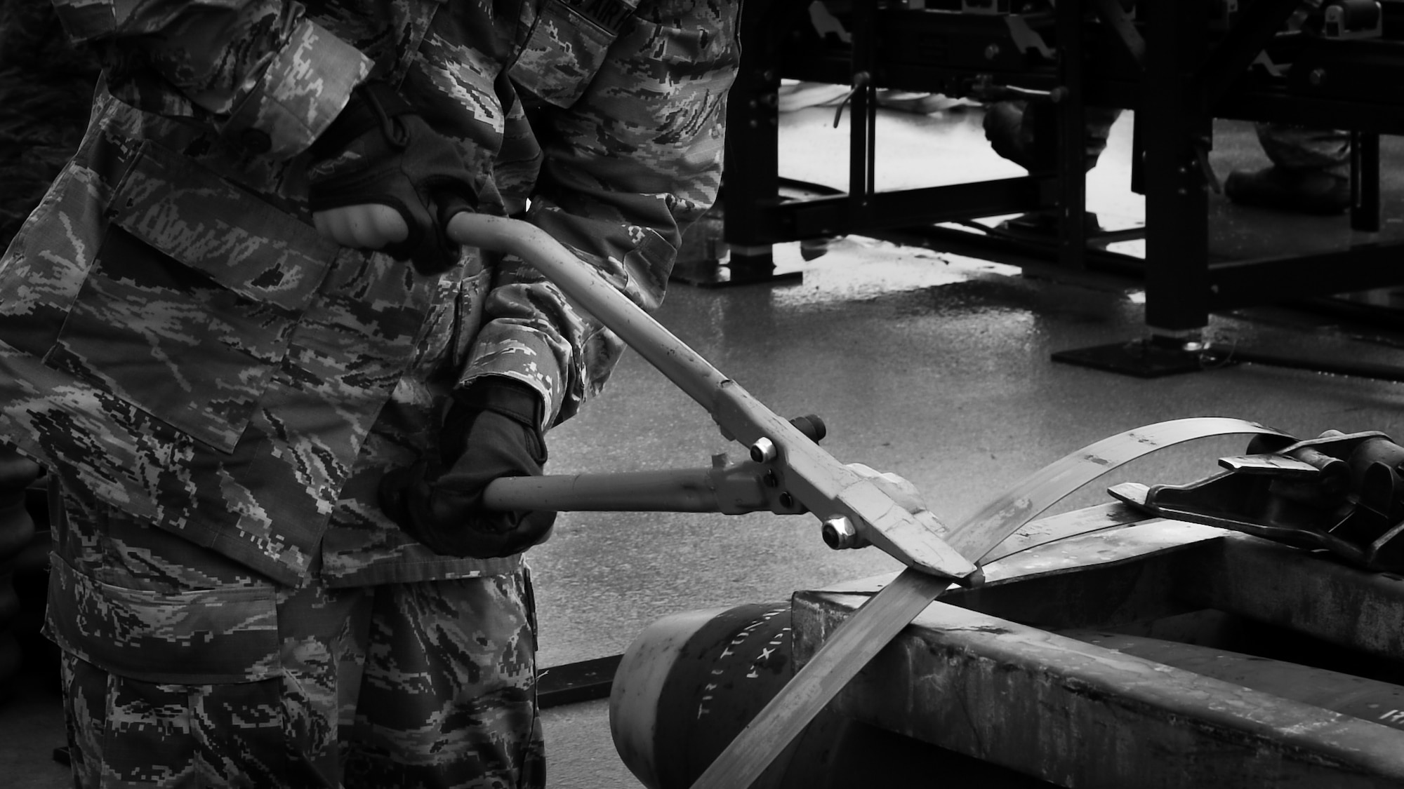 An Airman participating in Combat Ammunition Production Exercise 2018 cuts a wire on a container of munition bodies that have been disassembled on Gwangju Air Force Base, Gwangju, Republic of Korea, May 7, 2018.