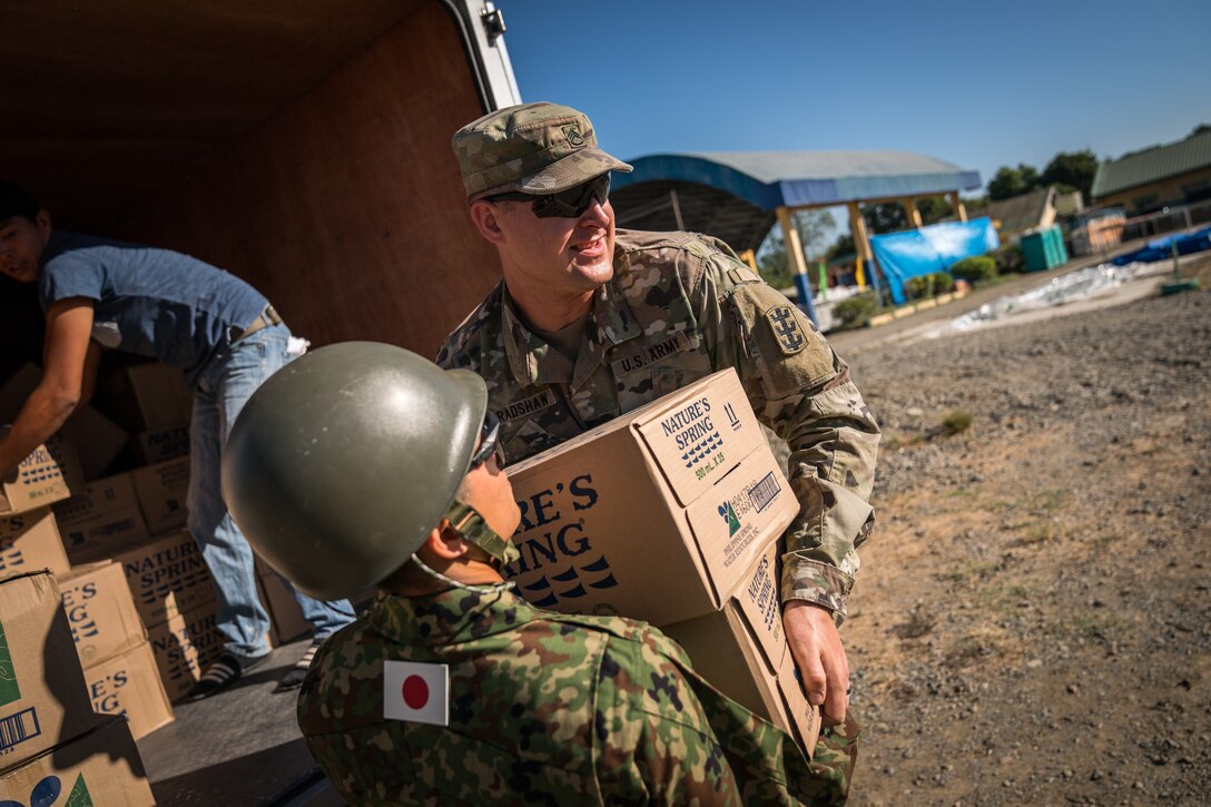 United States and Japan Ground-Self Defense Force soldiers unload boxes of water from a supply truck at Cabu Elementary School in Cabanatuan City, Nueva Ecija, Philippines, in support of Exercise Balikatan, April 20, 2018. Balikatan 34-2018, in its 34th iteration, is an annual U.S.-Philippine military training exercise focused on a variety of missions, including humanitarian assistance and disaster relief, counterterrorism and other combined military operations held from May 7 to 18. (U.S. Marine Corps photo by Sgt. Matthew J. Bragg)