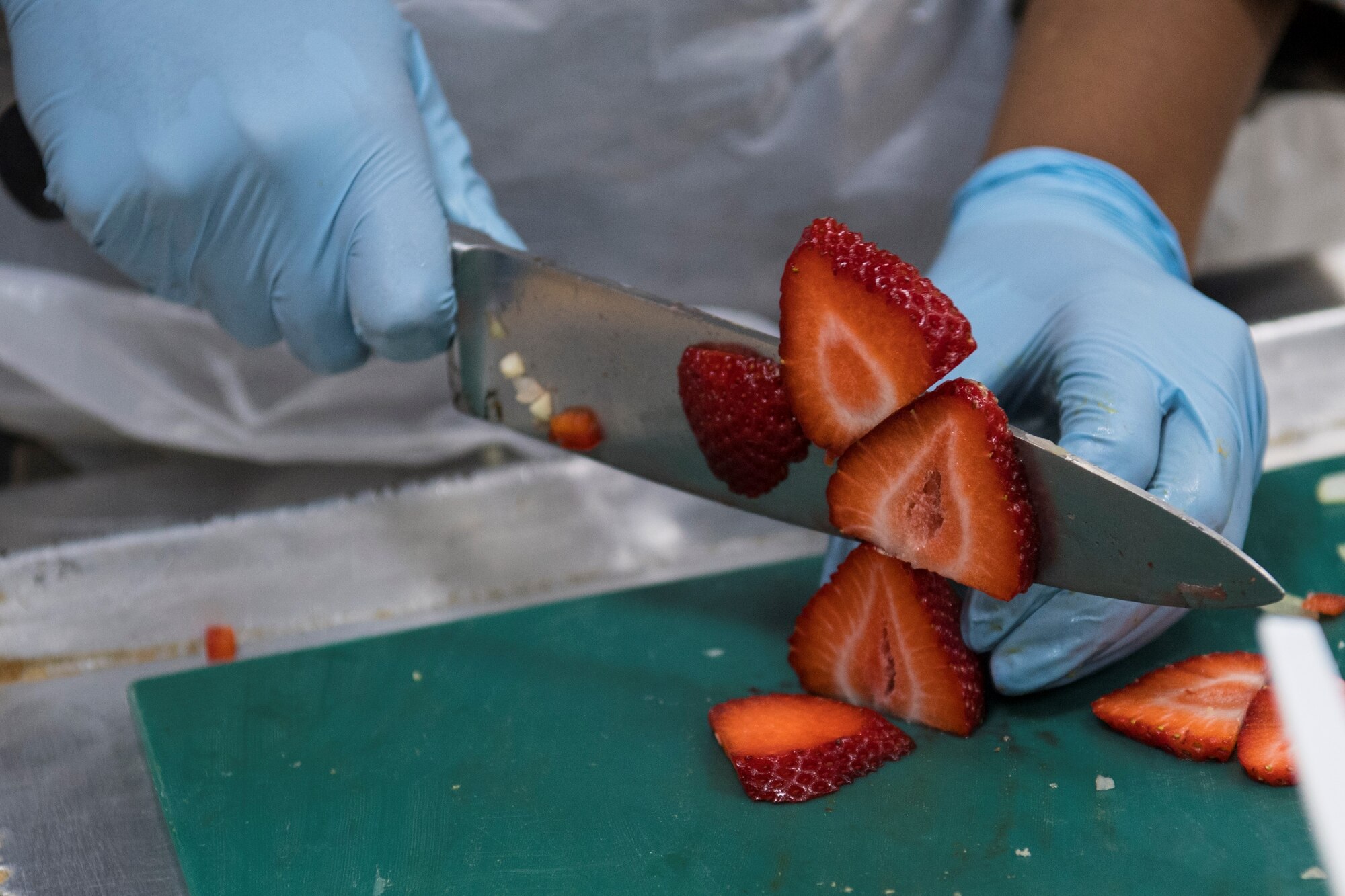 Tech. Sgt. Kadesha Mullgrav, 386th Expeditionary Force Support Squadron rations team, cuts strawberries at the ‘Chopped on the Rock’ cooking competition at an undisclosed location in Southwest Asia, May 9, 2018. Mullgrav placed third in the competition. (U.S. Air Force photo by Staff Sgt. Joshua King)