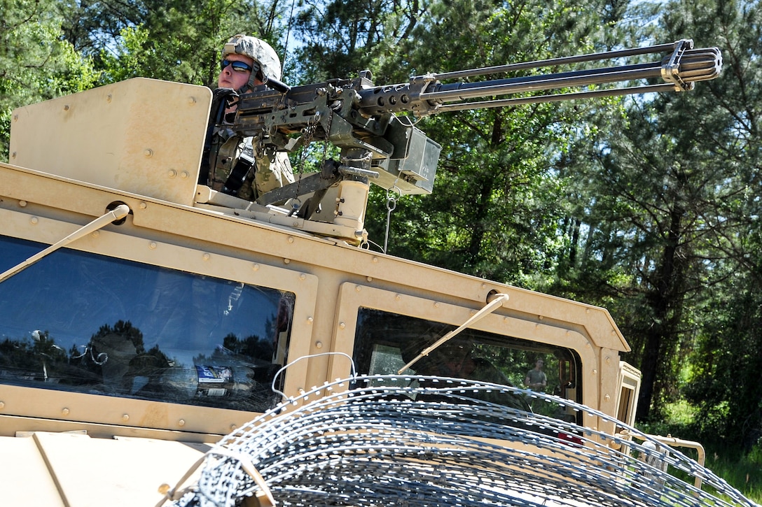 A soldier provides security atop a Humvee.