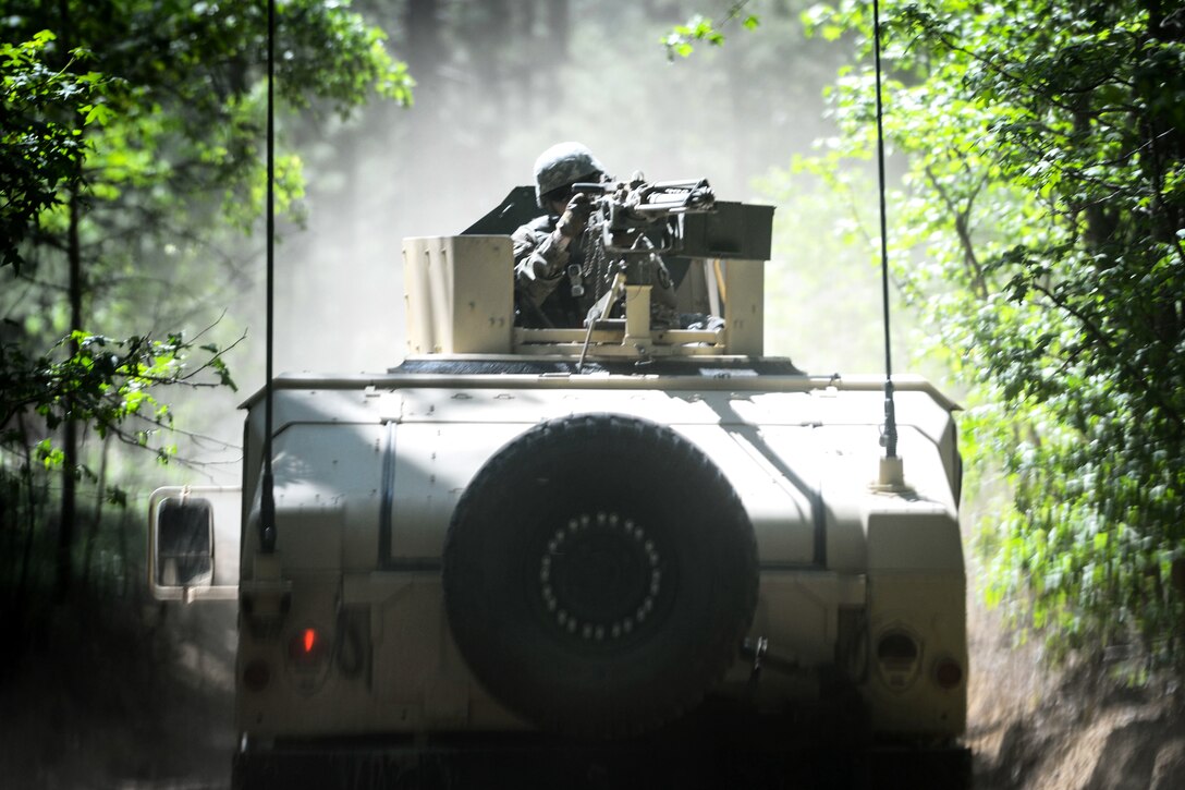 A soldier provides security atop a Humvee.