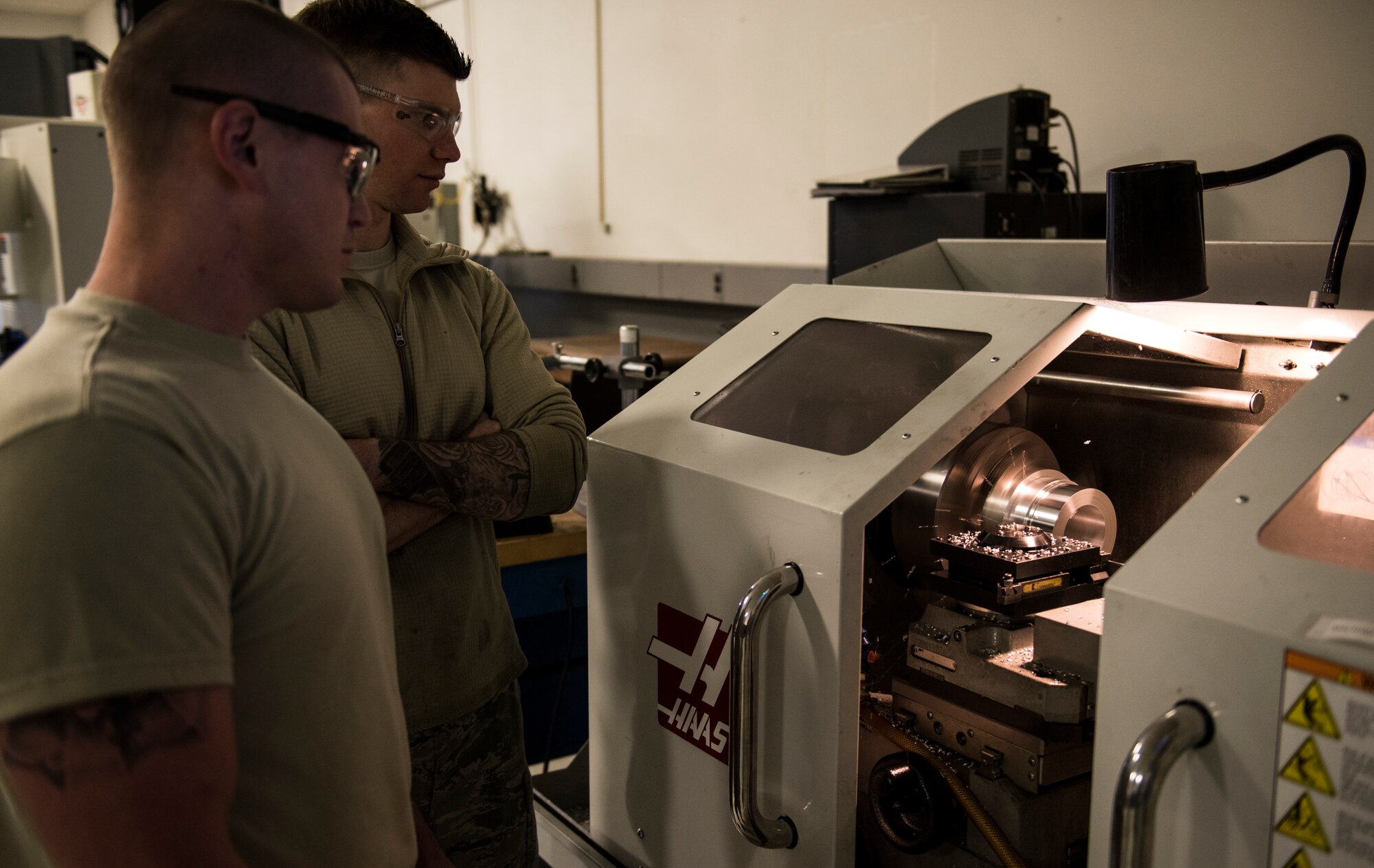 Staff Sgt. Steven Doucette, 92nd Maintenance Squadron aircraft metals technology shift lead, and Staff Sgt. Steven Bultemeier, 92nd MXS aircraft metals technology craftsman, use the Computer Numerically Controlled lathe April 26, 2018, at Fairchild Air Force Base, Washington. The CNC lathe is imperative to reverse engineering and manufacturing the main inlet fuel coupling needed to refuel coalition aircraft. (U.S. Air Force photo/Senior Airman Sean Campbell)