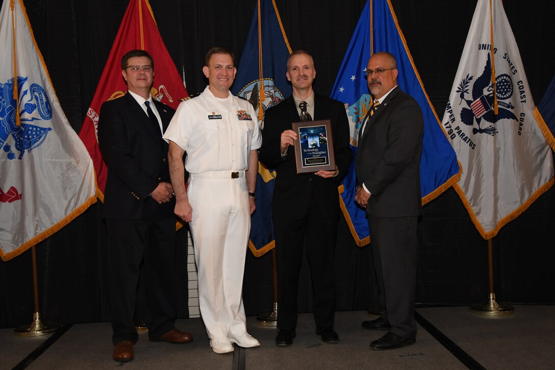 IMAGE: The Improved Point Detection System, Lifecycle Replacement Form, Fit, Function Repair Team received the Technology to the Warfighter Award at the NSWCDD Honorary Awards Ceremony held at the Fredericksburg Expo and Conference Center, April 26. The Technology to the Warfighter Award recognizes individuals or groups who have had a notable and significant impact on the warfighter by developing needed capability and transitioning it into operations. The intent of this award is to recognize direct contributions to the warfighter and their operational impact.