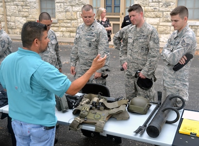 U.S. Marshal Marc Seguin (left) talks about some of the equipment he uses to Security Forces members at the opening of National Police Week May 15 at the Quadrangle at Joint Base San Antonio-Fort Sam Houston.