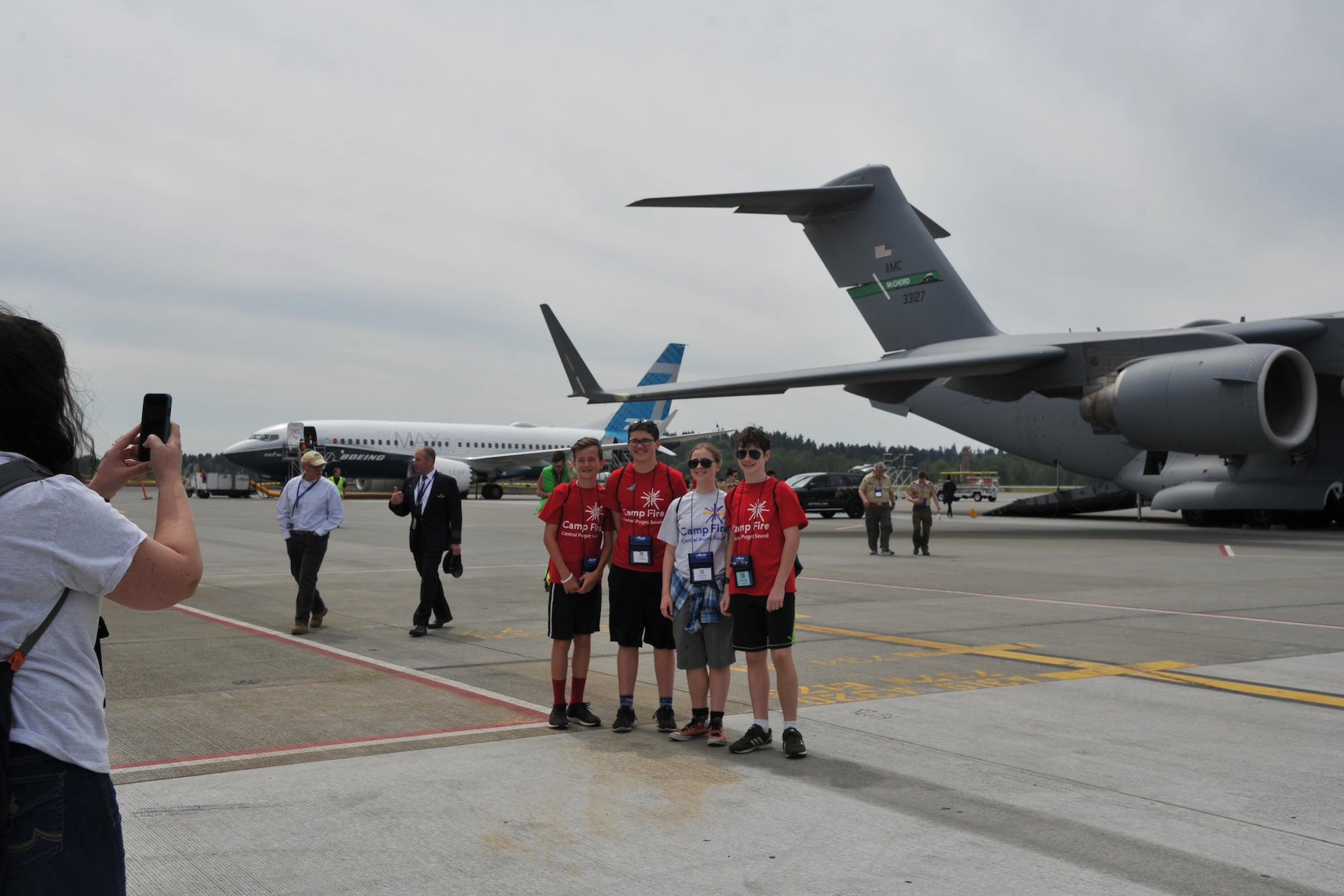 Stacy Cotton, chaperone, takes a photo of members of Robot Camperz, a co-ed group of Camp Fire Central Puget Sound, in front of the C-17 Globemaster III static display during the Alaska Airlines Aviation Day event May 5, 2018 at Seattle-Tacoma International Airport.