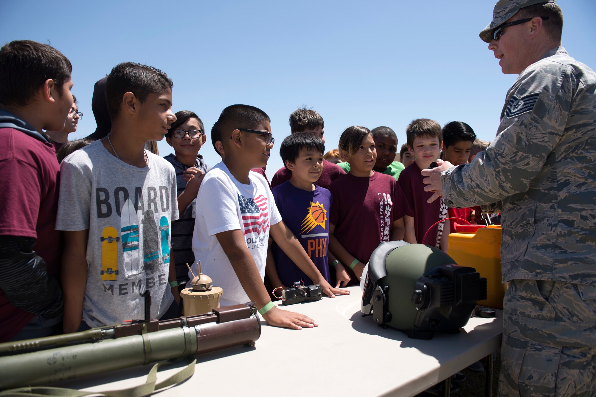 A 56th Civil Engineer Squadron explosive ordnance disposal technician talks about his equipment and work with a group of students from L. Thomas Heck Middle School April 20, 2018, in Litchfield Park, Ariz. The 56th CES EOD joined several flights of Airmen from the 56th Security Forces Squadron in visiting the middle school. (U.S. Air Force photo by Senior Airman Ridge Shan)