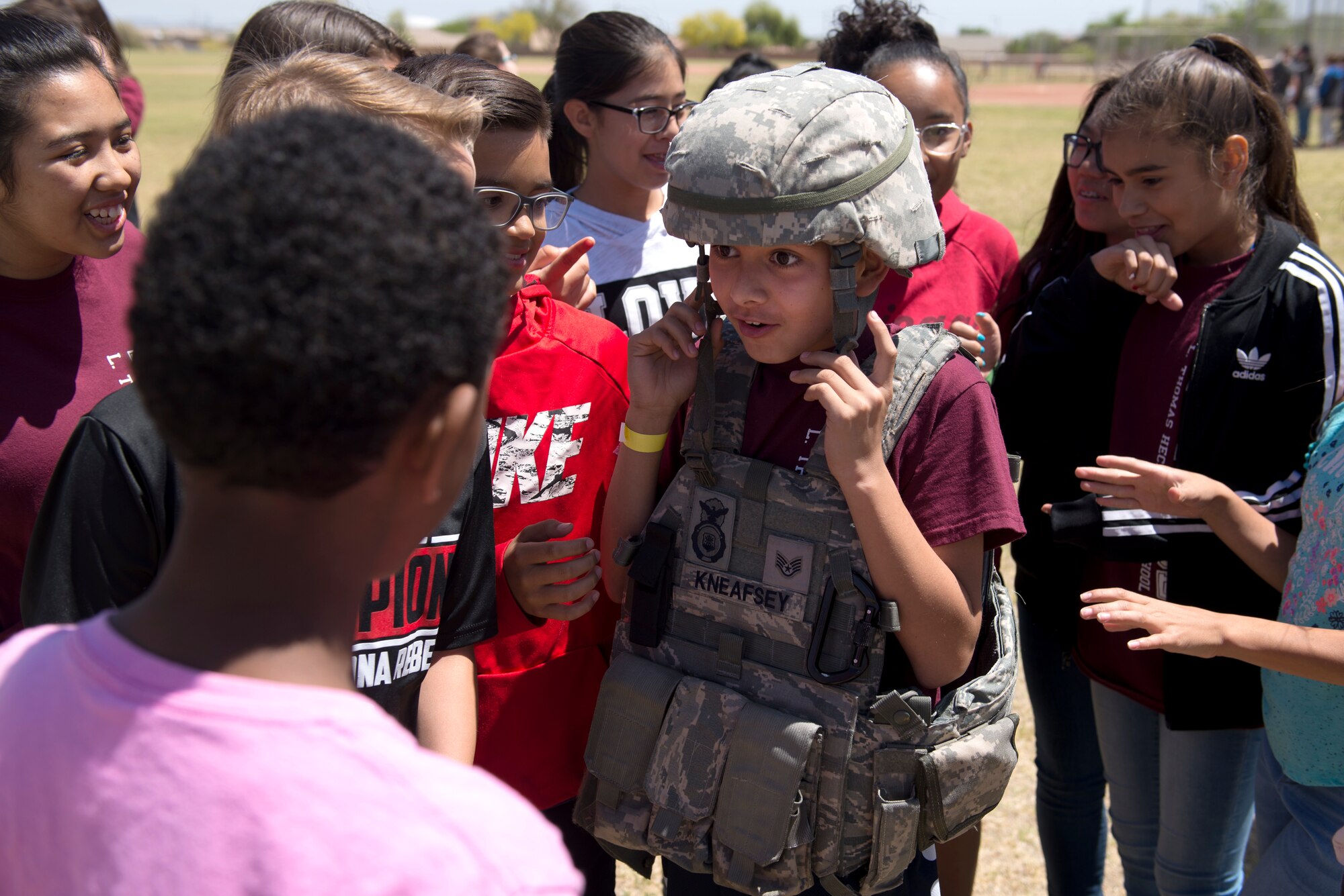 A student tries on the protective vest and helmet of a 56th Security Forces Squadron patrolman April 20, 2018, at L. Thomas Heck Middle School, Litchfield Park, Ariz. The 56th SFS and a group of explosive ordnance disposal Airmen from the 56th Civil Engineer Squadron provided displays for students who collected food and entertainment material to send care packages to deployed service members. (U.S. Air Force photo by Senior Airman Ridge Shan)