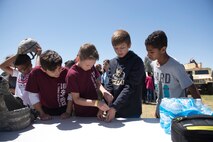 Students from L. Thomas Heck Middle school fiddle with police handcuffs during the 56th Security Forces Squadron visit April 20, 2018, in Litchfield Park, Ariz. Students from each grade had a chance to interact with and learn from Luke Air Force Base Airmen. (U.S. Air Force photo by Senior Airman Ridge Shan)