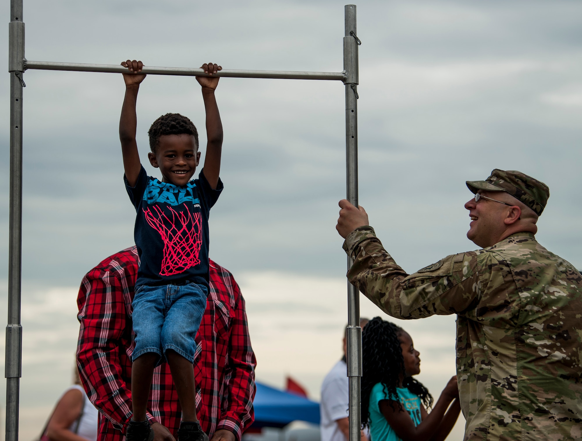 A child tries out a pull-up bar at a U.S. Army recruitment tent during Tampa Bay AirFest 2018 at MacDill Air Force Base, Fla., May 13, 2018.