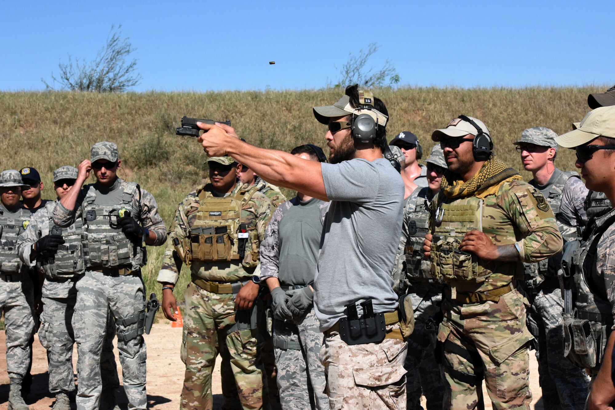 The Shooting Institute chief executive officer, Jared Hudson, demonstrates how to fire a pistol during the Special Weapons and Tactics and Close Quarters Combat training at the Goodfellow Air Force Base shooting range in San Angelo, Texas, May 9, 2018. Students learned how to properly handle a pistol to hit targets quickly, without harming non-targets. (U.S. Air Force photo by Airman 1st Class Seraiah Hines/Released)