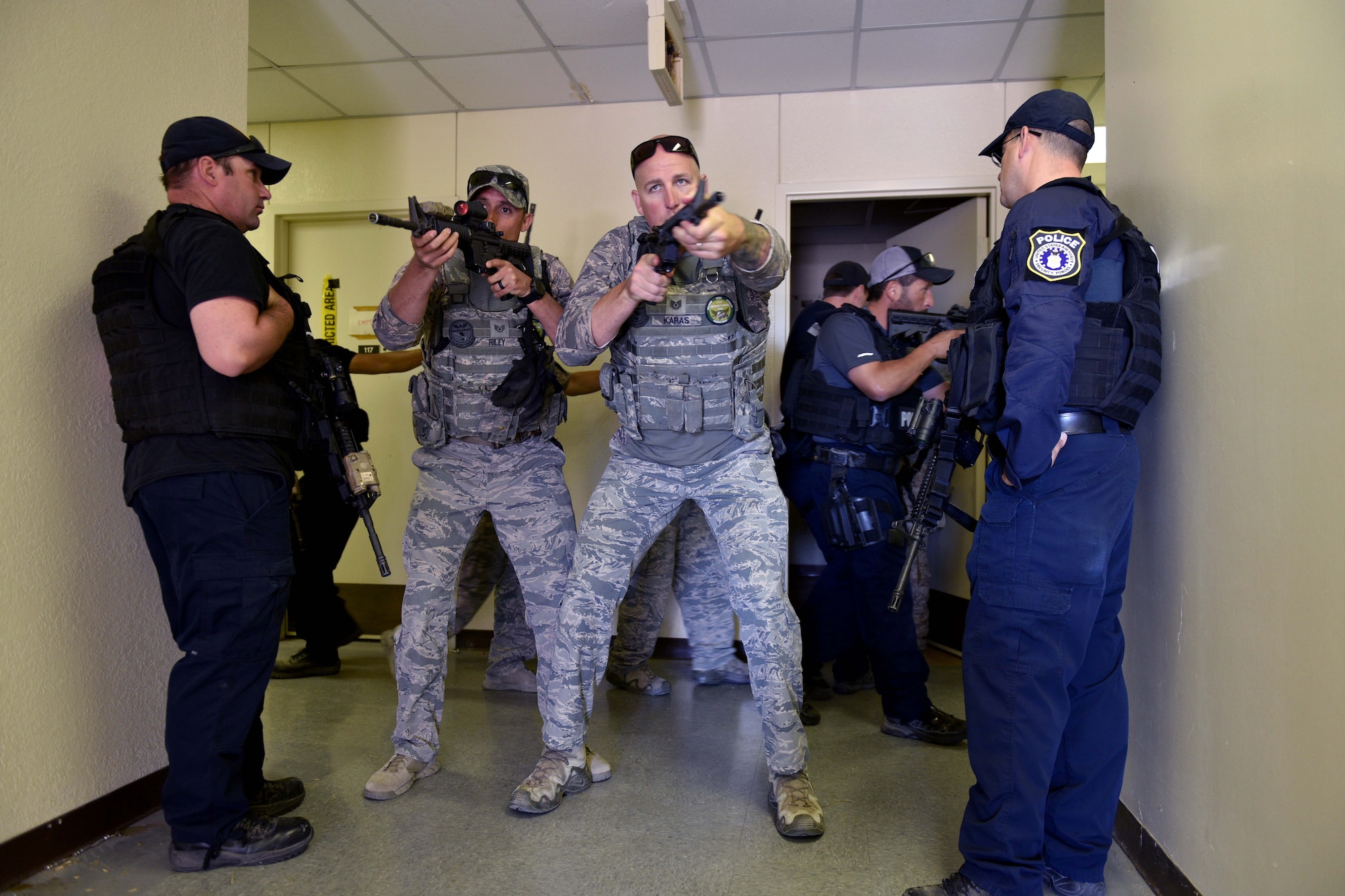 U.S. Air Force Staff Sgt. Mark Riley, 17th Security Forces Squadron unit trainer, and Tech Sgt. Mark Karas, 17th SFS noncommissioned officer in charge, perform close quarters combat maneuvers during the Special Weapons and Tactics and Close Quarters Combat training at the Eldorado Air Force Station in Eldorado, Texas, May 10, 2018. The training would start in a classroom, then move to a firing range or the Eldorado Air Force Station. There, the students would implement their training with drills and simulation rounds. (U.S. Air Force photo by Senior Airman Randall Moose/Released)