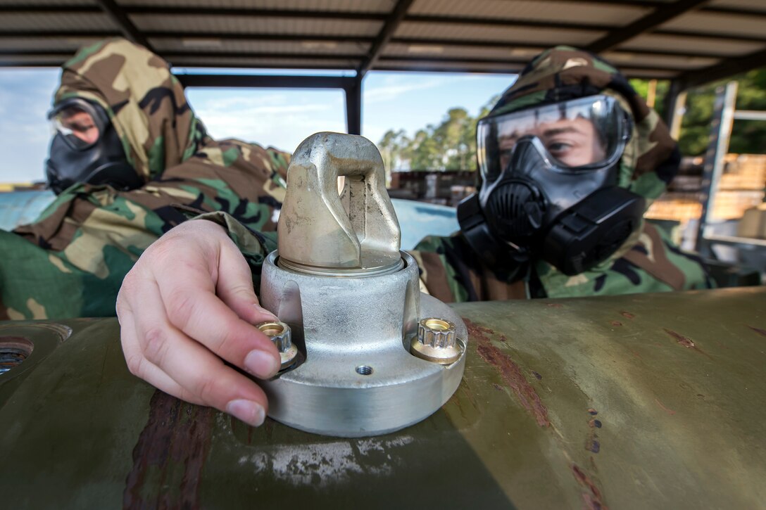 Staff Sgt. Patricia Lee, 23d Maintenance Squadron munitions technician, unscrews the barrel locks attached to a Joint Direct Attack Munition (JDAM) during a bomb building course, May 10, 2018, at Moody Air Force Base, Ga. To ensure readiness to complete their mission efficiently, Airmen practiced constructing a JDAM while wearing Mission Oriented Protective Posture gear to further simulate what their mission could entail. (U.S. Air Force photo by Airman 1st Class Eugene Oliver)