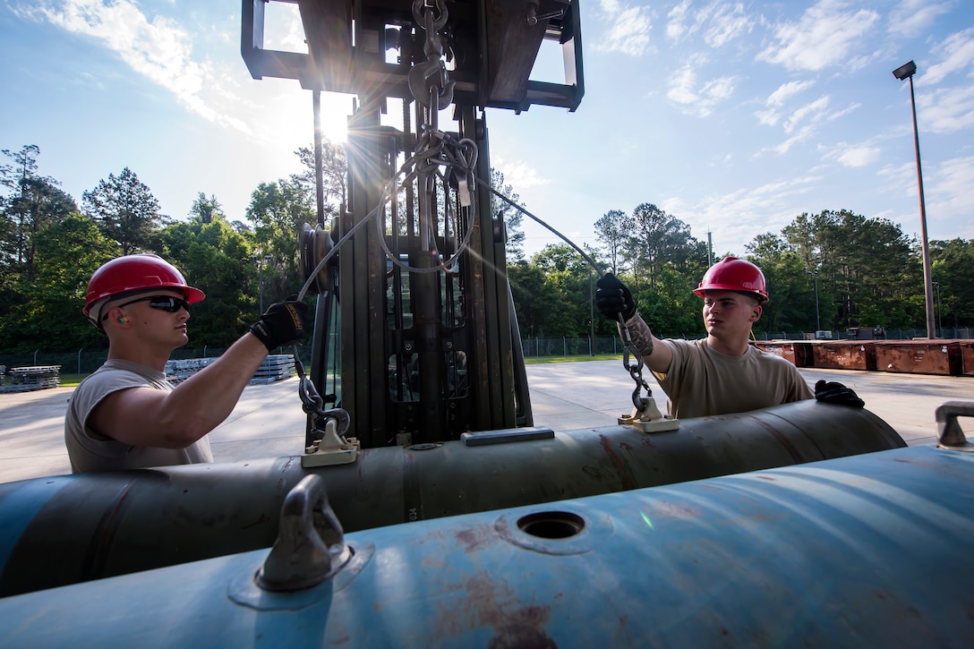 Airmen from the 23d Maintenance Squadron, attach forklift hooks to the barrel locks of a Joint Direct Attack Munition (JDAM), May 10, 2018, at Moody Air Force Base, Ga. To ensure readiness to complete their mission efficiently, Airmen practiced constructing a JDAM while wearing Mission Oriented Protective Posture gear to further simulate what their mission could entail. (U.S. Air Force photo by Airman 1st Class Eugene Oliver)