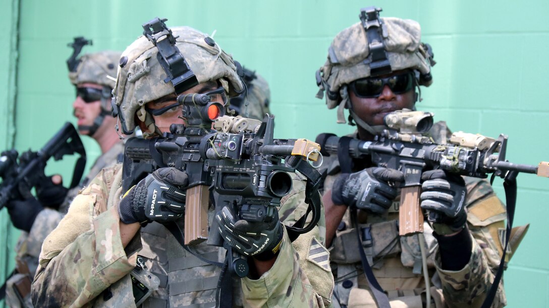 Three soldiers holding weapons move together.